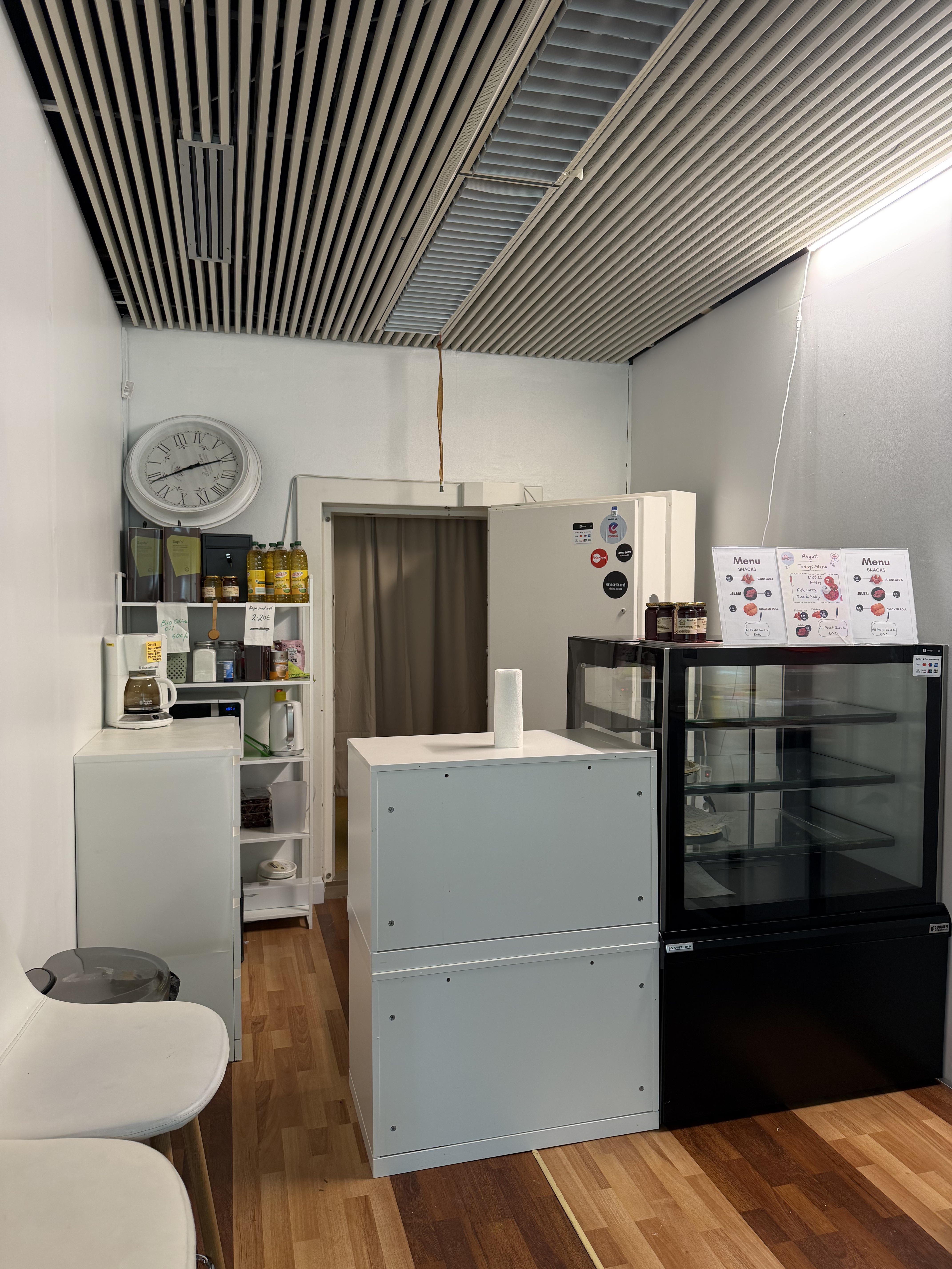 A pantry and snack-prep area at EMC's business lounge, with a menu board and refreshment fridge