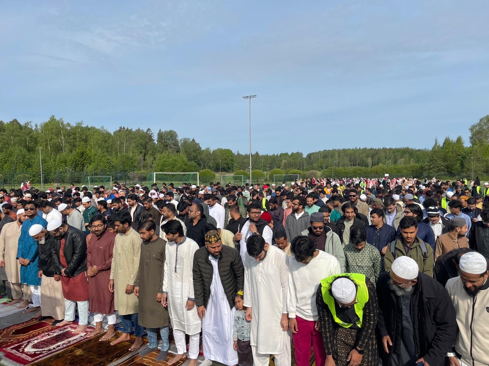 A large outdoor congregation gathered for Eid prayer at EMC