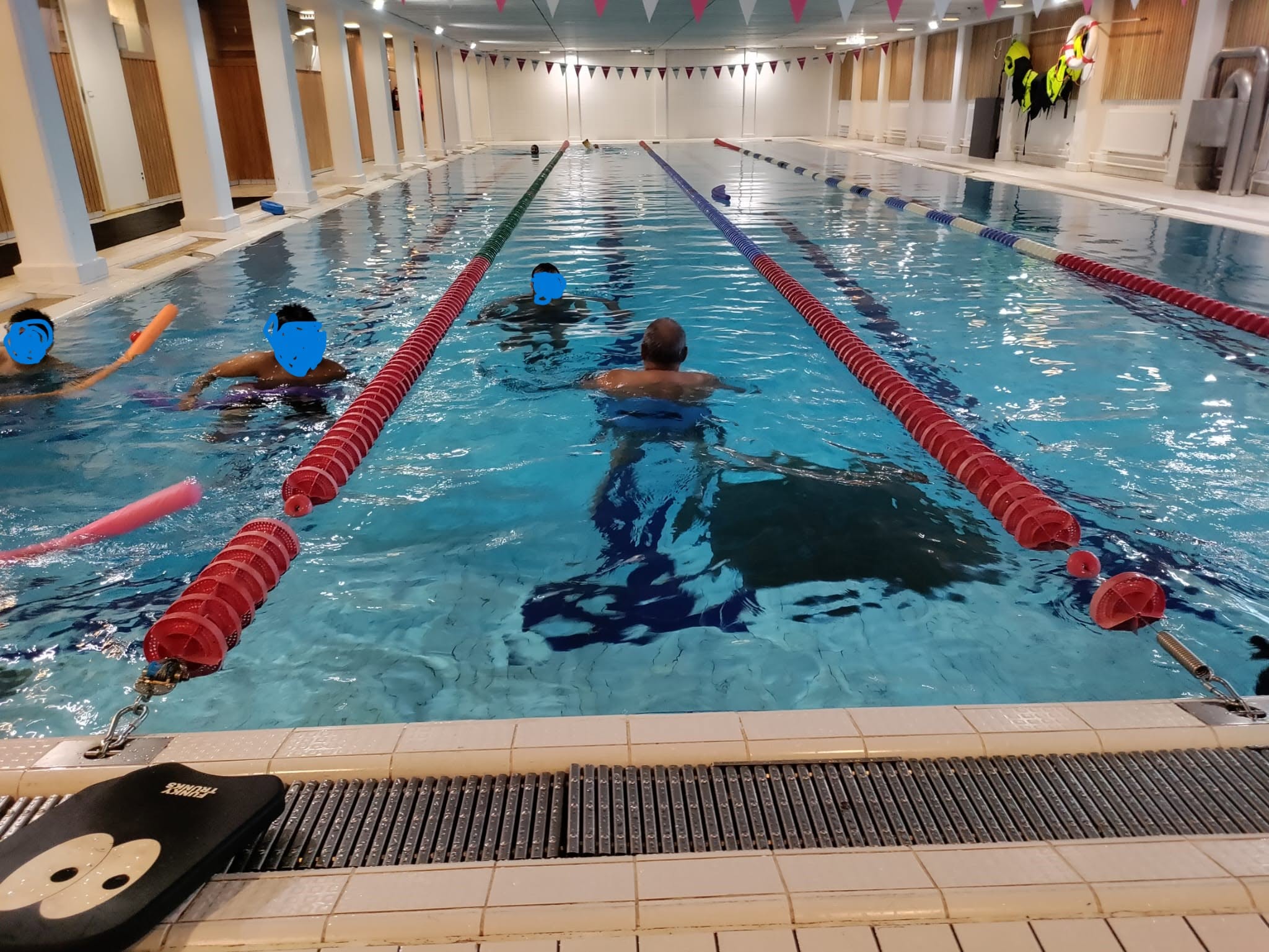 Swimmers taking part in an EMC swimming session at an indoor pool