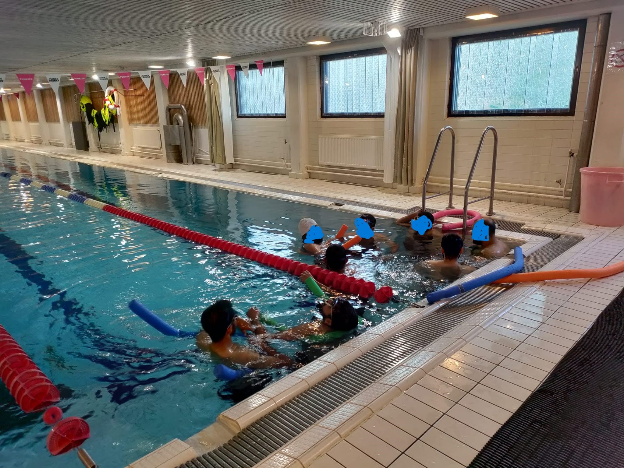 Swimmers taking part in an EMC swimming session at an indoor pool