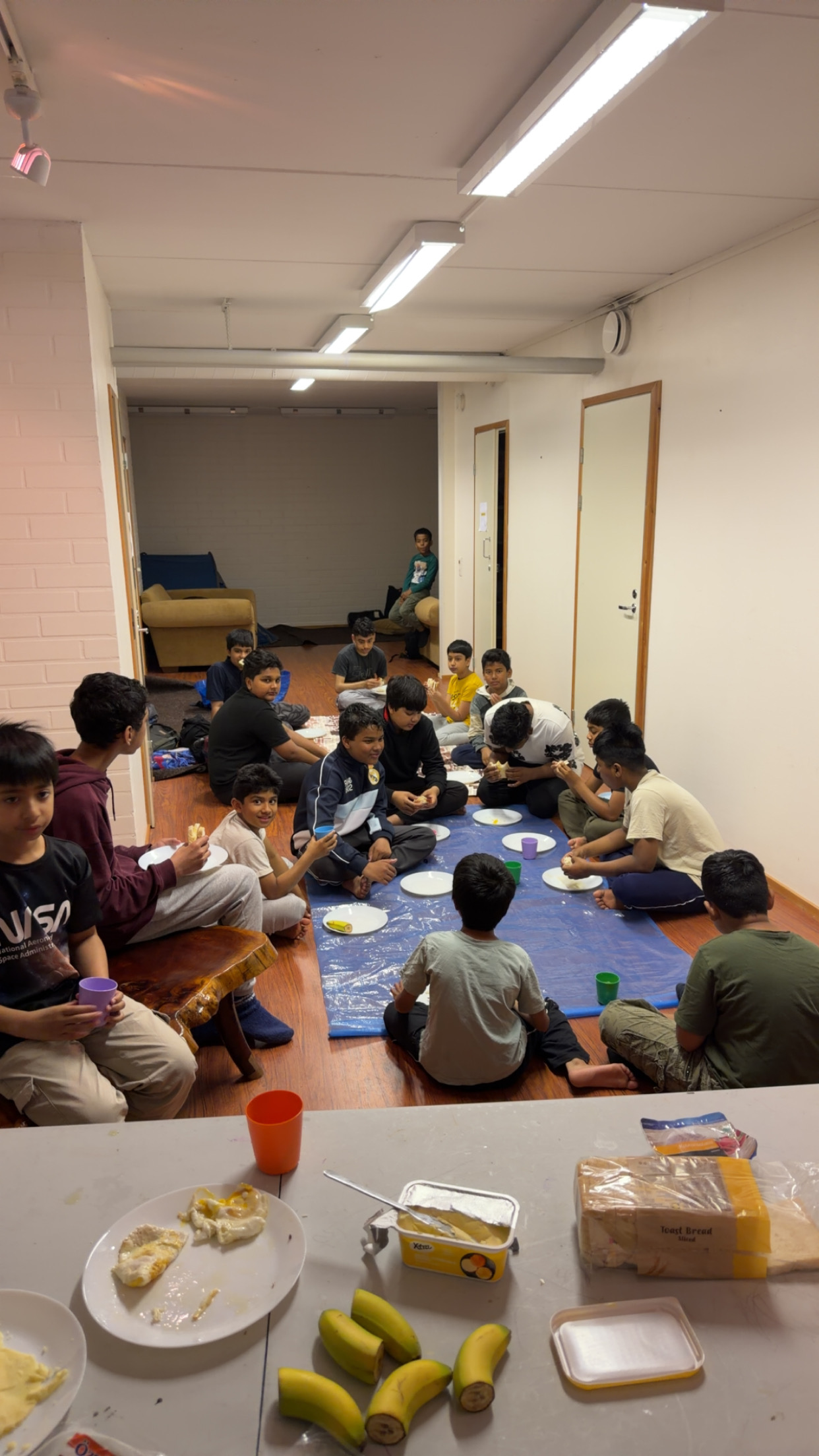 Youth sharing a meal together on the floor at an EMC youth session